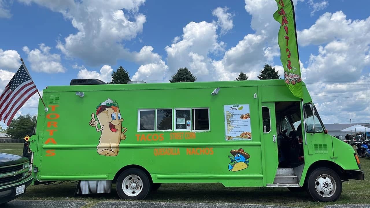 Side view of the green Juanito’s Tacos food truck parked and ready to serve in Champaign-Urbana