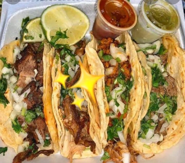 Street tacos topped with fresh salsa and a wedge of lime at Juanito’s Tacos